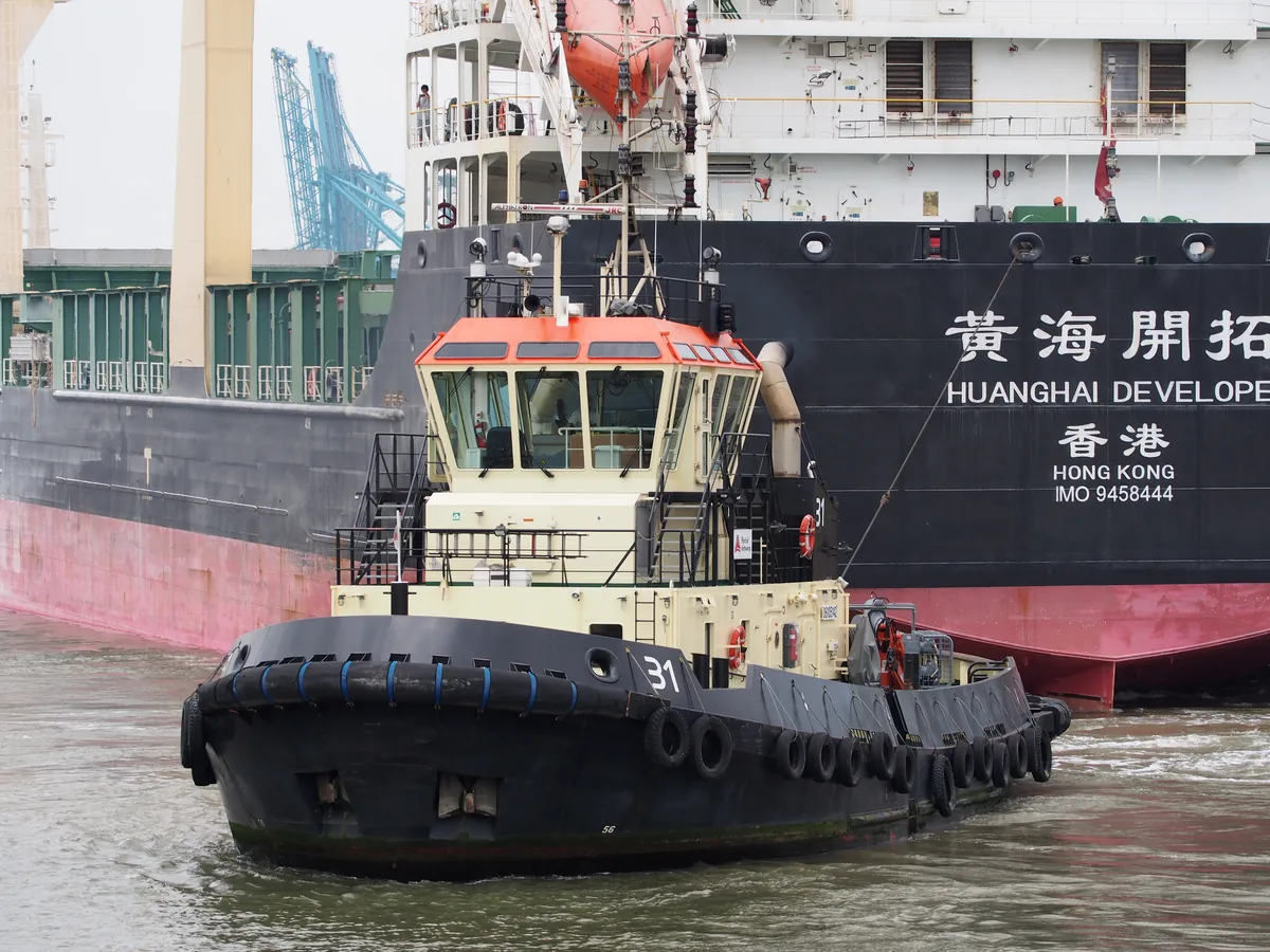 Tugboat supporting a vessel during port operations